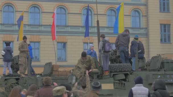 Natos Operation i Opole ungdomar på en Panzer tak militärfordon personer vid utställning av militär utrustning på ett torg vifta med flaggor — Stockvideo