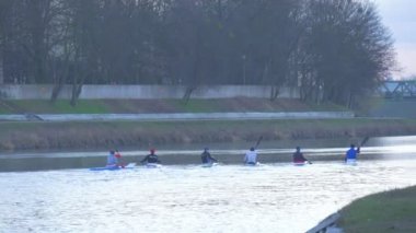 Altı sporcular kürek Kayak bir Kano Glide nehrin tekneler Green Park Nehri su demiryolu Köprüsü yakınlarında tarafından gidiş bulutlu gün Dusk