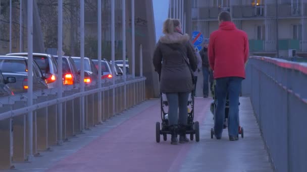 City Day in Opole Poland People on a Sidewalk Evening Cityscape Traffic Headlights Pedestrians Cars Are Driven Buildings Road Signs Family With Baby Prams — Stock Video