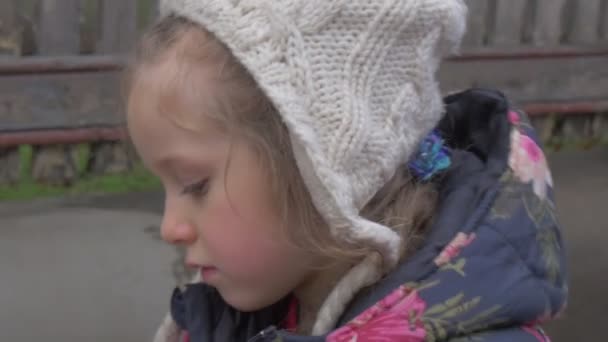 Sad Kid Girl Complains Talks Annoyed Little Child Unties Her Scarf Plays Outdoors Blonde Kid in Flowered Jacket and White Hat Red Face Girl Cries Winter — Stock Video