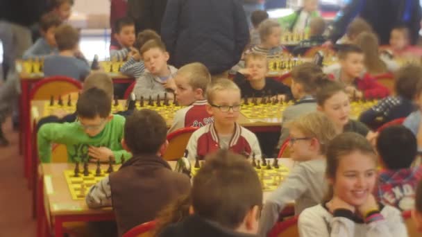 Mamme e papà con i bambini al torneo di scacchi Gioca a "Cavaliere nero" Club Le persone camminano tra le tabelle degli scacchi Strategia Gioco da tavolo Opole Polonia — Video Stock