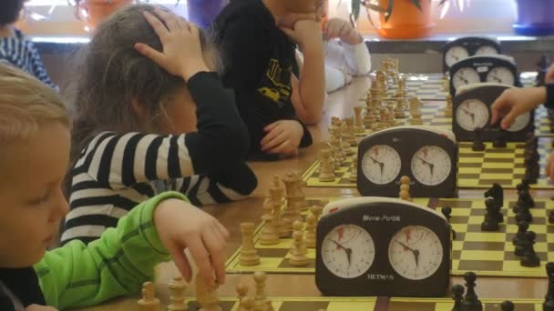 Gyermekek játék a sakk, és hogy a lépések sakk-bajnokság szervezője az Event sakk Club "fekete lovag" stratégia társasjáték Opole Lengyelország — Stock videók