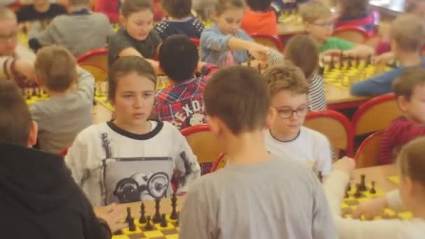 Entuzjastyczne dzieci w turnieju Chess Club "Czarny rycerz" ludzie chodzą w sali szachowej klubu strategia gry planszowe Opole Polska — Wideo stockowe