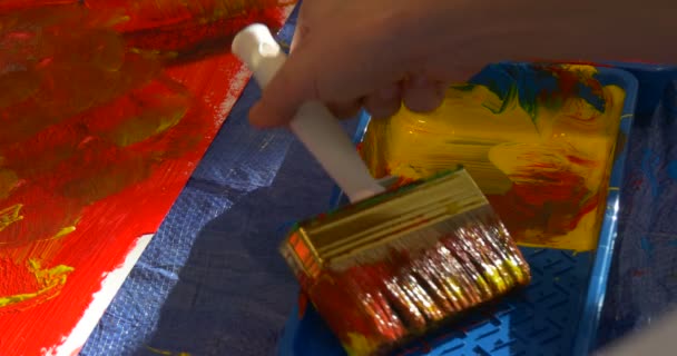 Jemand steckt einen Pinsel in Farbschale Menschen malen im Kindergarten Erzieher Animateure unterhalten die Kinder bunt bemalt Bilder verbringen Zeit miteinander — Stockvideo