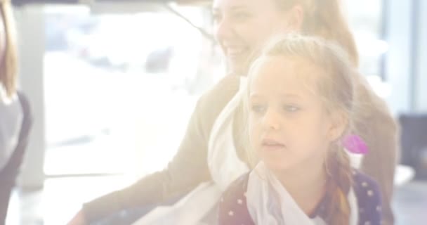 Barn och pedagoger sitter i konsthallen leende människor Paint i Kindergarten klassrummet lärare och liten blond flicka animatörer familjer föräldrar — Stockvideo