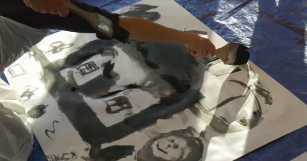 Kinderhand zeichnet Haus mit Schwarz auf Papier Familienmeisterkurs in Kunstgalerie Menschen sitzen auf einem Fußboden Farbe in Klassenzimmer Pädagogen und Kinder Animatoren — Stockvideo