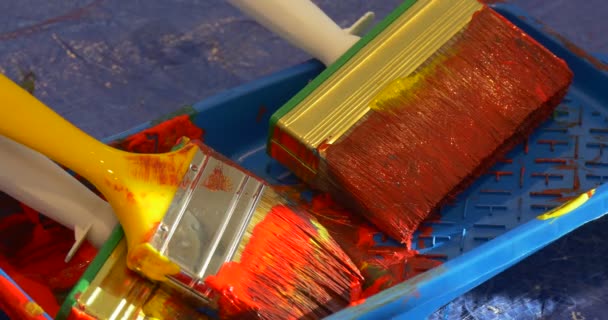 Mano toma un pincel sucio de una bandeja de pintura Los niños están pintando en la galería de arte Personas en el jardín de infantes Educadores Animadores Entretener a los niños — Vídeo de stock