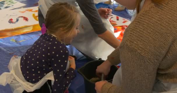 Kleine Mädchen waschen den Pinsel in einem Eimer Gemälde in der Kunstgalerie bunte Bilder auf einem Papier auf dem Boden des Klassenzimmers Kindergarten Familie Meisterklasse — Stockvideo