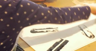 Erkek kadın ve çocuklar oyun masasında lastik pullar aileleriyle sınıf eğitimciler animatörler içinde büyük kağıda bir pul koymak boya vardır