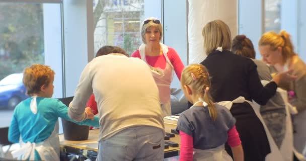 Familia Master Class Opole Modern Art Gallery Grupo de personas en delantales Niños juegan con sellos de goma Pintura en hojas grandes de papel Aula Educadores y niños — Vídeo de stock