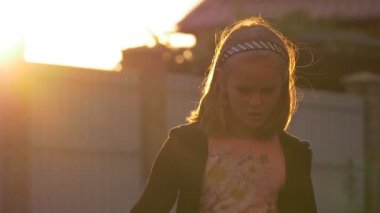 Çocukları bahçesinde Bahçesi adlı, ayakta, portre, Talking, arka plan günbatımı ışınları dönüm olan kız sarışın saç kesme