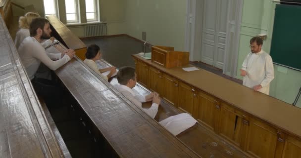 Profesor, chemik, biolog, učitel drží třídu před studenty, mladí lidé poslouchají — Stock video