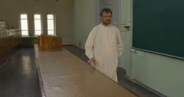 Profesor, Hombre, Químico, Biólogo en Túnica Médica Blanca está celebrando la clase en el escritorio, Estudiantes en la lección, Chica está saliendo de la clase — Vídeos de Stock