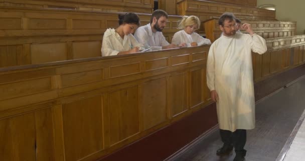 Professeur, chimiste, biologiste, enseignant tient la leçon, classe, devant les élèves, marche par auditorium, discussion — Video