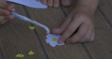 Sarı Saçlı Küçük Kız, Pembe T-Shirt Ve Gri Pantolon, Bir Katta Oturuyor, Renkli Kağıt, Sarı Middles ile Birlikte Beyaz Çiçekler Katıldı