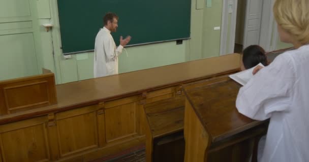 Professor, man, scheikundige, Biologst is Holding hoorcollege, les, leraar, studenten in Auditorium, Amphitheater, twee meisjes studenten, Blonde Girl — Stockvideo