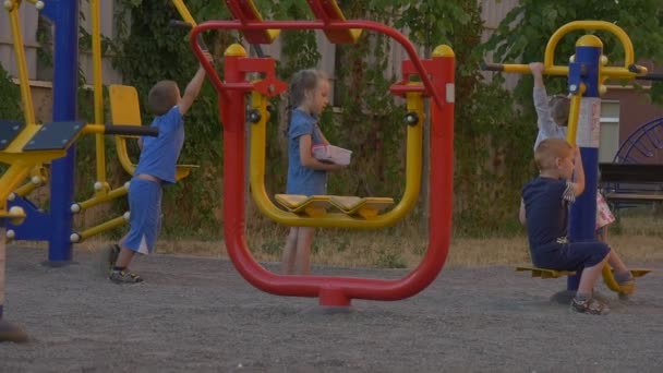 Kinderen spelen op de speelplaats in de tuin — Stockvideo