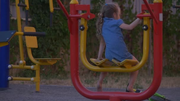 Petite fille dans les balançoires bleues haut et bas — Video