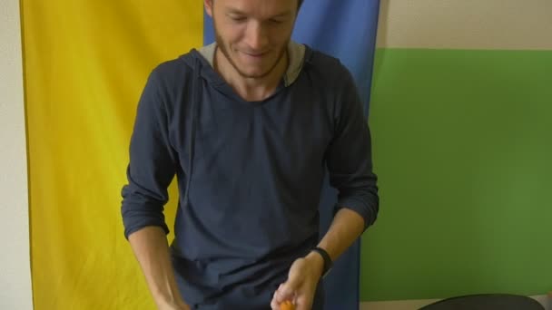 Посміхатися Young Man є жонглює три абрикосів, український прапор на тлі — стокове відео