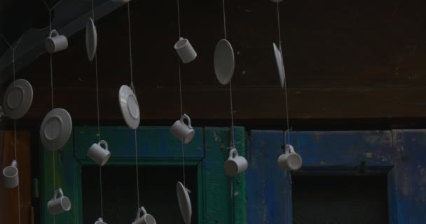 Two Men are Passing by Camera, White Mugs, White Saucers, Hunging Under The Ceiling on The Threads, Metal Construction of Ceiling — Stock Video