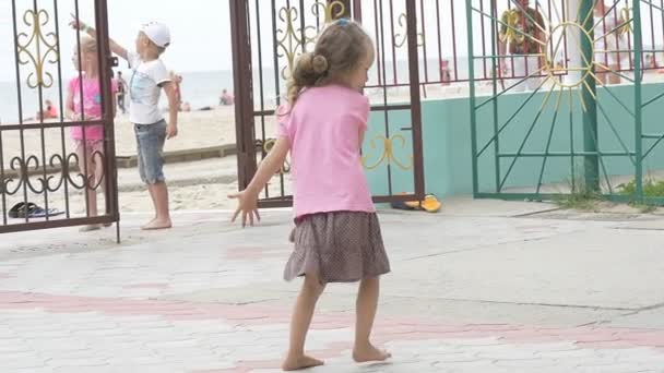 Gyerekek, gyerekek játszanak a játszótéren, Girl in Pink póló is imbolygott, fordult a kapu, fiú és lány jönnek — Stock videók