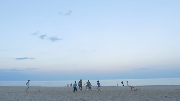 Ludzie, dzieci, rodzin są w Sandy Beach, gra, odpoczynek, bieganie, wczesnym wieczorem, Grupa dzieci są gry piłka nożna — Wideo stockowe