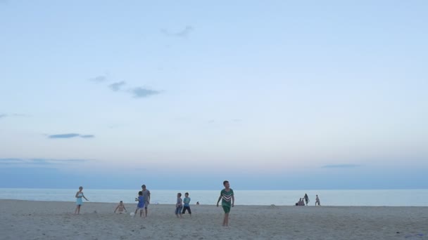 Gente de la costa del Mar Negro, niños, familias están en la playa de arena, jugando, descansando, corriendo, temprano en la noche, grupo de niños están jugando, jugando al fútbol — Vídeos de Stock