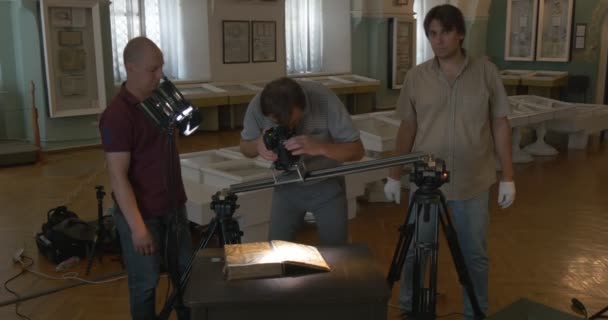 Три оператори стоїш, беручи, відео, відео зйомки історичних книг. Стародавні машини, інструменти для друку, Києво-Печерська Лавра — стокове відео