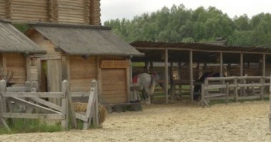 İstikrarlı bir kulübe, ahşap çit, Sandy stadyum, günlük duvar altında üç at