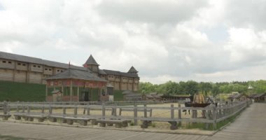 İki aktörler, biniciler atları üzerinde Ridind Sandy stadyum, antik kent duvarı, bulutlar tarafından vardır