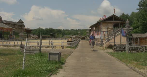 Horseman gaat weg door de houten weg door de oude stad, Museum in open lucht — Stockvideo