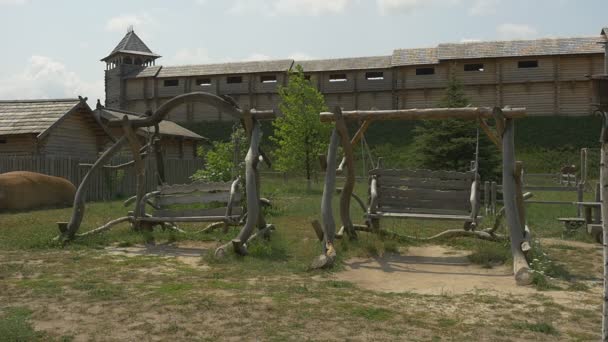 Holzbalkenschaukeln, Schaukeln, Zeitlupe, uralte Stadtmauer im Hintergrund — Stockvideo