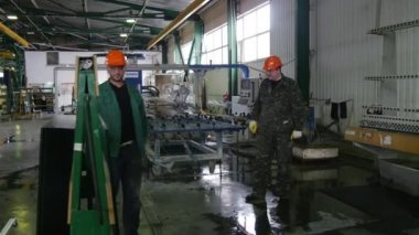 Üç İşçi, Turuncu Güvenlik Kasklı Adamlar, Adam Standdan Cam Levhaaldı ve Makineye Levha koydu