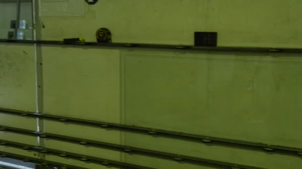 Работник в заводской униформе кладет стекло в машину, производственная линия стекла, пуленепробиваемое стекло, триплекс стекла, испытания на присутствие Аргона — стоковое видео