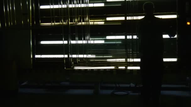 Worker is Observing The Process of Testing For Argon Presence, Dark Room, Light Inside of The Window Panes, Production Line of of Glass — Stock Video