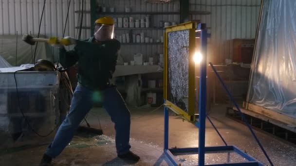 Trabajador en uniforme y pantalla protectora, guantes amarillos, está golpeando la hoja de vidrio de Hummer, Pruebas de vidrio a prueba de balas, Lamplight — Vídeos de Stock