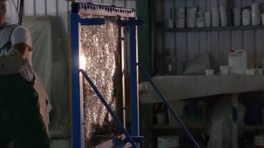 Üniformalı ve Koruyucu Ekranlı İşçi Hummer 'dan Cam Sayfaya Yaklaşıyor ve Vuruyor, Cam Sayfa Metal Çerçevede, Ayakta, Cam Çatlaklar