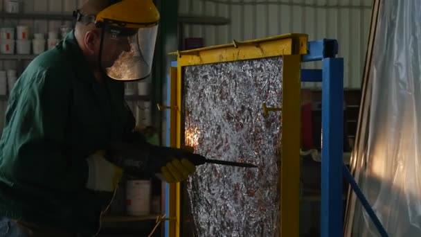 Taladro de cerca, Zoom de distancia, Trabajador en uniforme y pantalla protectora está perforando la hoja de vidrio por punzón, Hoja de vidrio en marco de metal, Grietas en vidrio — Vídeos de Stock