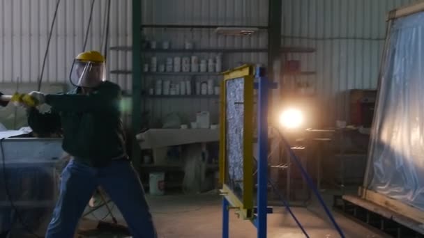 Trabajador en uniforme y pantalla protectora, guantes amarillos, está golpeando la hoja de vidrio de Hummer, Pruebas de vidrio a prueba de balas, Lamplight — Vídeos de Stock