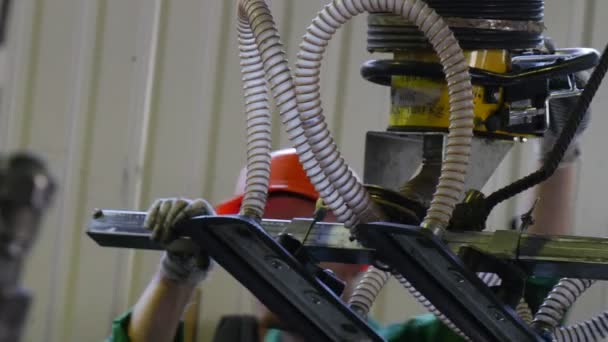 Trabajador en uniforme y casco de seguridad, guantes, el hombre está trabajando con la máquina manual, máquina con ventosas, transporte de la hoja de vidrio, fábrica de vidrio — Vídeo de stock