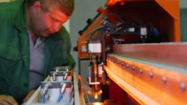 Trabalhador está olhando para baixo na máquina, Luz dentro da máquina, Trabalhador em uniforme na máquina, Coloque a folha de vidro na máquina — Vídeo de Stock