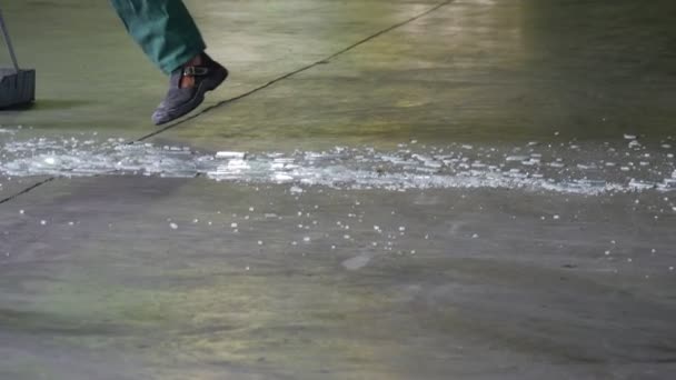 Zwei Arbeiter, Reinigungskräfte, grüne Uniform, Beine in Nahaufnahme, fegen den Boden, kehren das zerbröckelte Glas, kehren mit Besen — Stockvideo