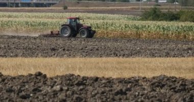 Traktör Toprak Tarla Bitkileri Çalılık Saman Arabalar Bir Ufukta Field Houses boyunca Yol tarafından tahrik edilir