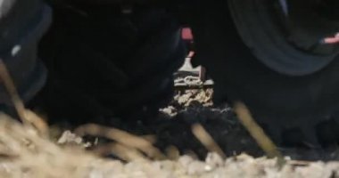 Traktör Close Up Sürücü Silueti Uçan Toz Yol ve Sokak Lambaları Bir Horizon Yeşil Ağaçlar ve Çalılar Evleri Yüksek Gerilim Kuleleri üzerinde Pulluk