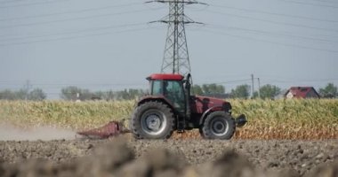 Traktör Bir Horizon Mavi Gökyüzü Üzerinde Alan Sürücü Siluet Uçan Toz Yüksek Voltaj Kuleleri ve Teller Pulluk olduğunu