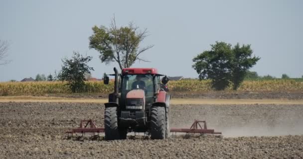 Tractor is Approaching The Camera Driver 's Silhouette Tractor is Plowing The Field Dust is Flying Road behind the Tractor Cars on the Road — Vídeo de Stock
