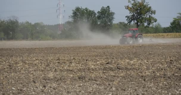 Vlečný traktor je rozlísný traktorem pole Plow traktor se blíží k polní silnici a pouliční lampy vysokonapěťová věž, traktor se posune doleva — Stock video