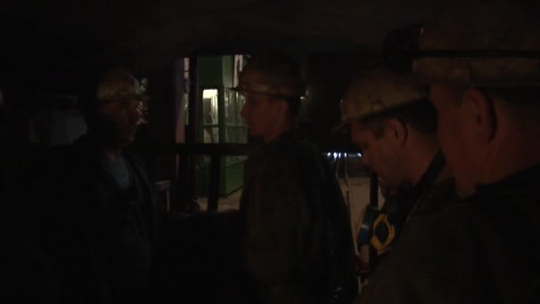 Arbeiter stehen in der Dunkelheit reden Bergleute Männer ist Schutzhelme und Lampen auf einem Helm Atemschutzmasken Männer arbeiten in der Mine — Stockvideo