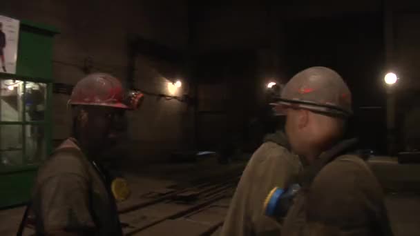 Tres trabajadores mineros se dicen adiós el uno al otro y se van Los hombres son cascos de seguridad y lámparas en cascos Respiradores Los hombres trabajan en la mina — Vídeo de stock