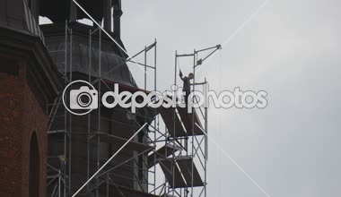 İki işçi siluet katedral kule kırmızı blok kilise Şapel bulutlu katedral restorasyon Opole Polonya'nın duvarlarının kuleleri çevresinde bir iskele üzerinde